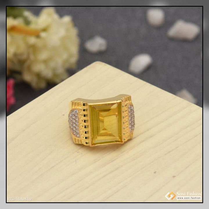 Gold plated yellow sapphire ring with diamonds on wood surface