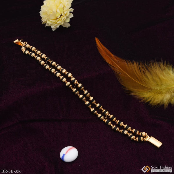 Feather, ball, and purple cloth on 2 Line Rudraksha Gold Plated Bracelet - B356