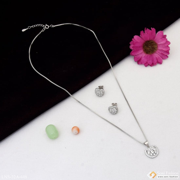 Sterling silver necklace set with three necklaces and a flower on table.